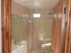 Fully tiled and featuring a walk-in monsoon shower.